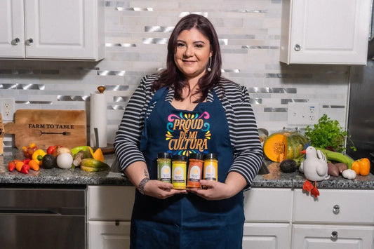 Healthy Rican founder holding Latin spices and seasonings in the kitchen while celebrating four years of healthier alternatives to traditional Puerto Rican dishes.