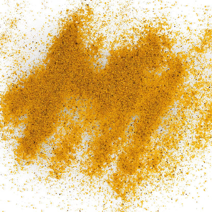 Loose Healthy Rican Adobo seasoning scattered on a white surface with golden Puerto Rican spices.