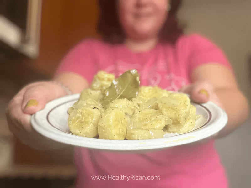 Guineos en Escabeche served on a plate with tender green bananas, onions, and bay leaves in a traditional Puerto Rican marinade.
