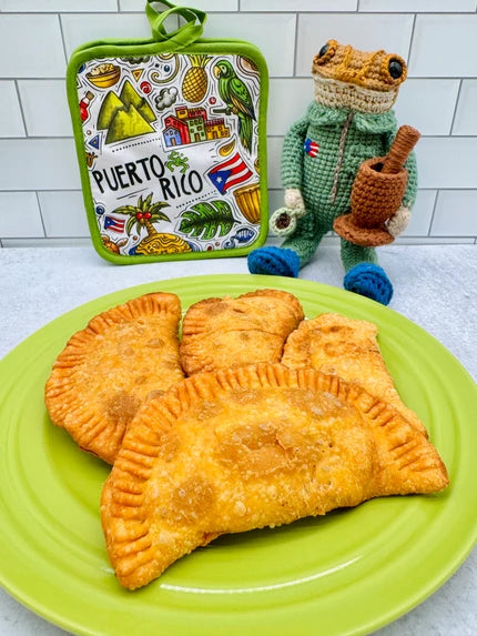 Puerto Rican empanadas and pastelillos served golden and crispy on a plate with Puerto Rico-themed kitchen decor in the background.
