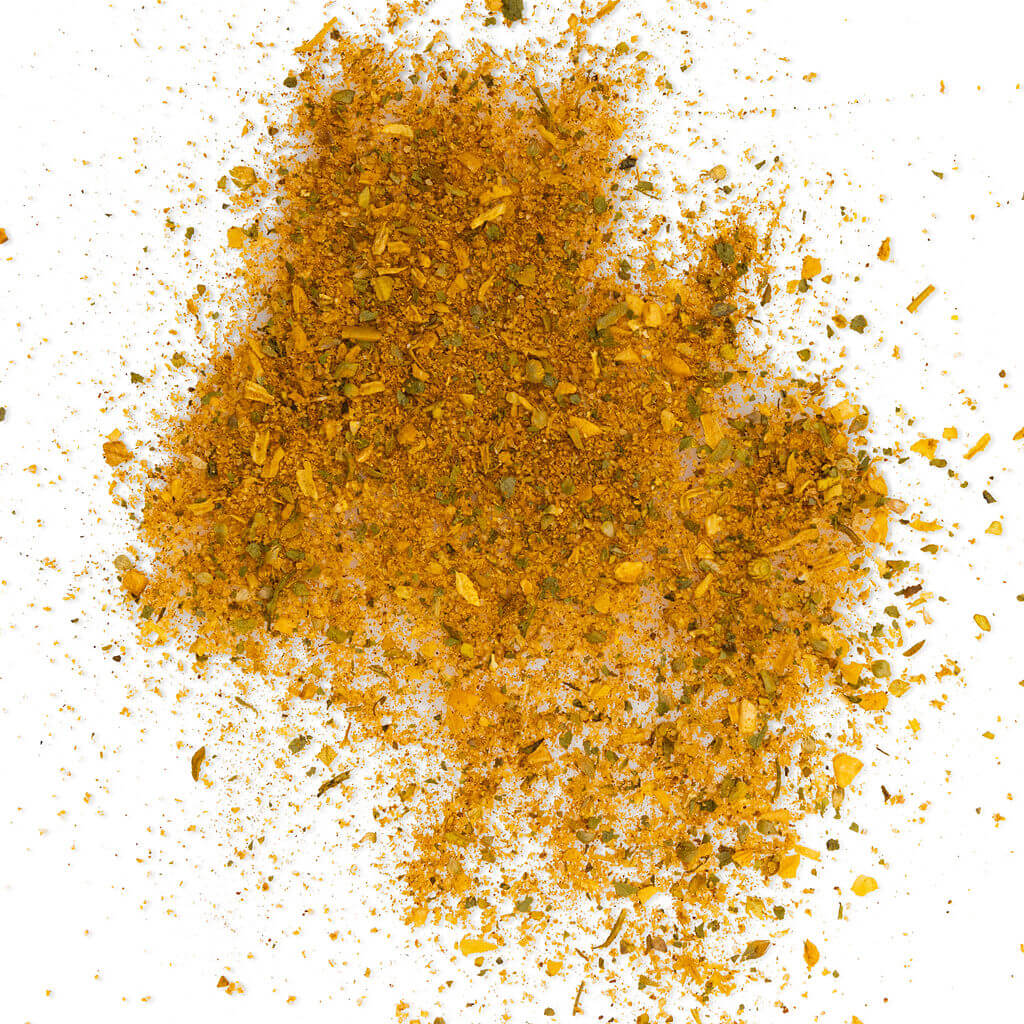Loose Healthy Rican Savory Chicken Mix scattered on a white surface with golden herbs and Puerto Rican spices.