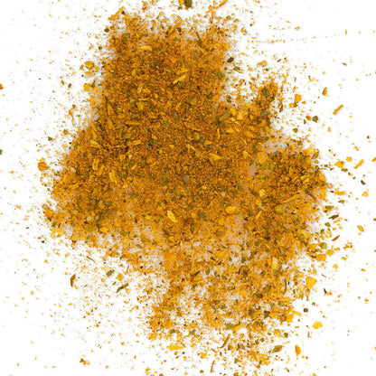 Loose Healthy Rican Savory Chicken Mix scattered on a white surface with golden herbs and Puerto Rican spices.