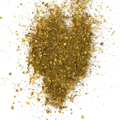 Loose Healthy Rican Sofrito seasoning scattered on a white surface with dried herbs and Puerto Rican spices.